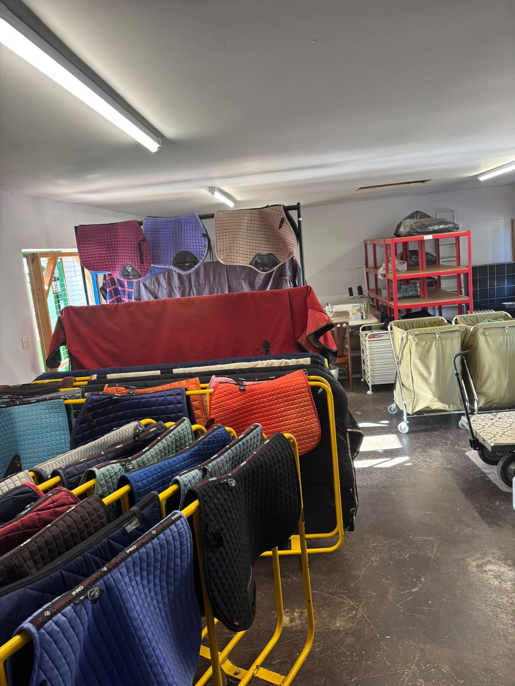 Rows of clean horse rugs hanging on drying rails